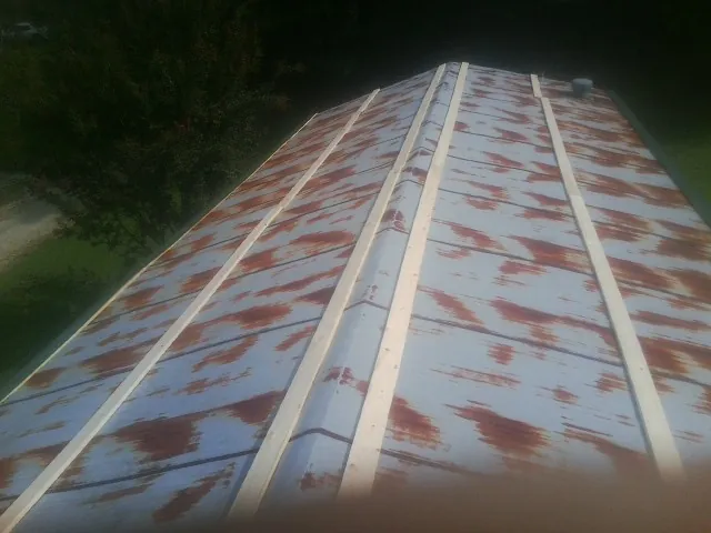 Rusted metal roof panels with new wood purlins before replacement — Storm Damage Roof Repair in Oakman by Roofing Brothers