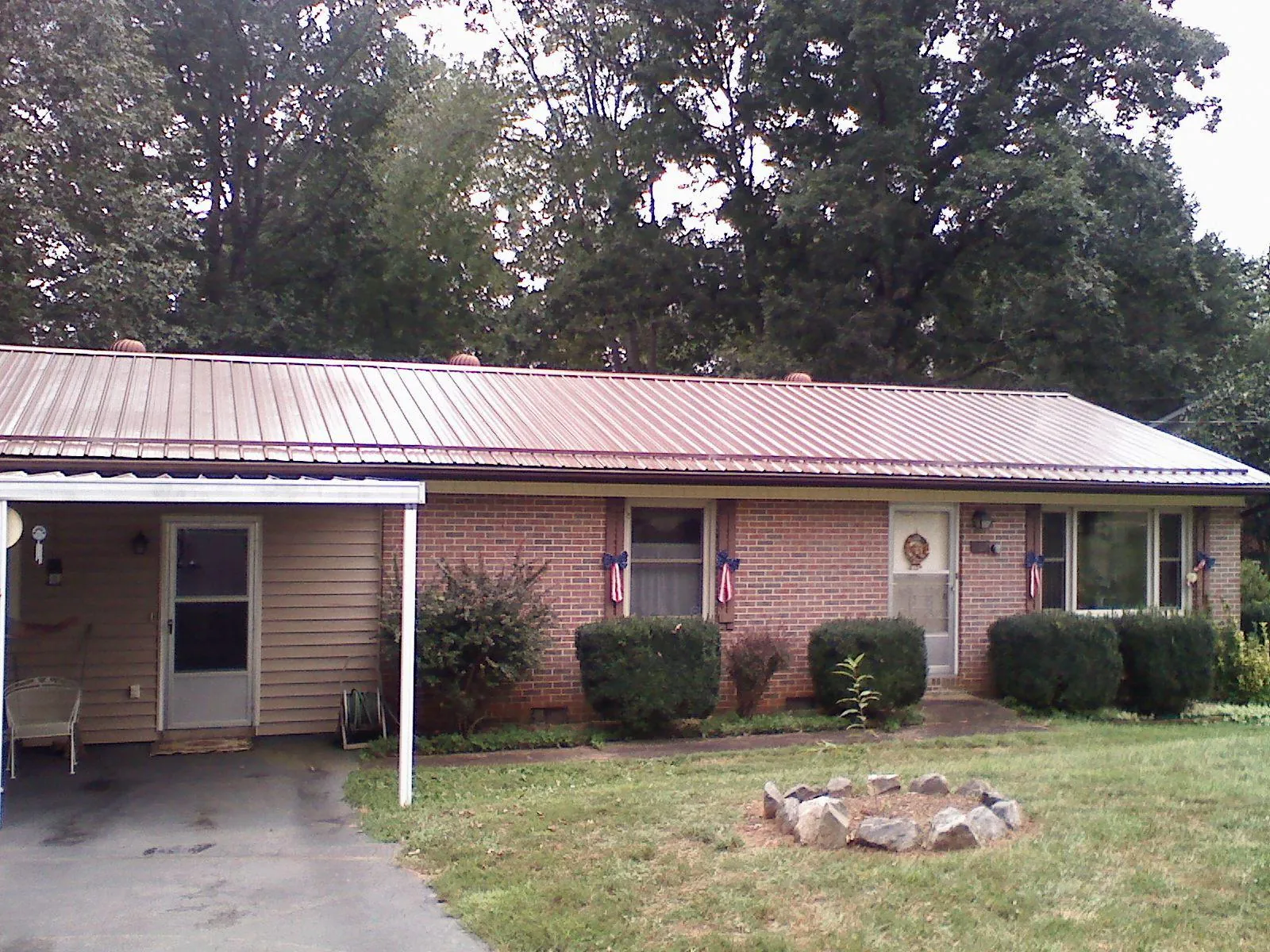 Bronze metal roof and carport on a brick ranch home — Roof Repair work by our crew in Oakman