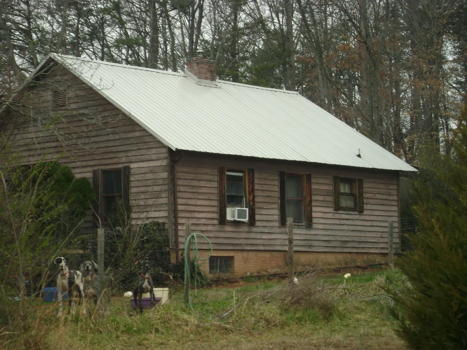 White metal roof on an old wood sided farmhouse, from a Metal Roof Installation job in Oakman